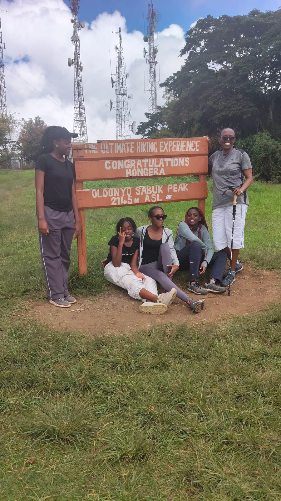 Family group gathered at the Oldonyo Sabuk Peak sign