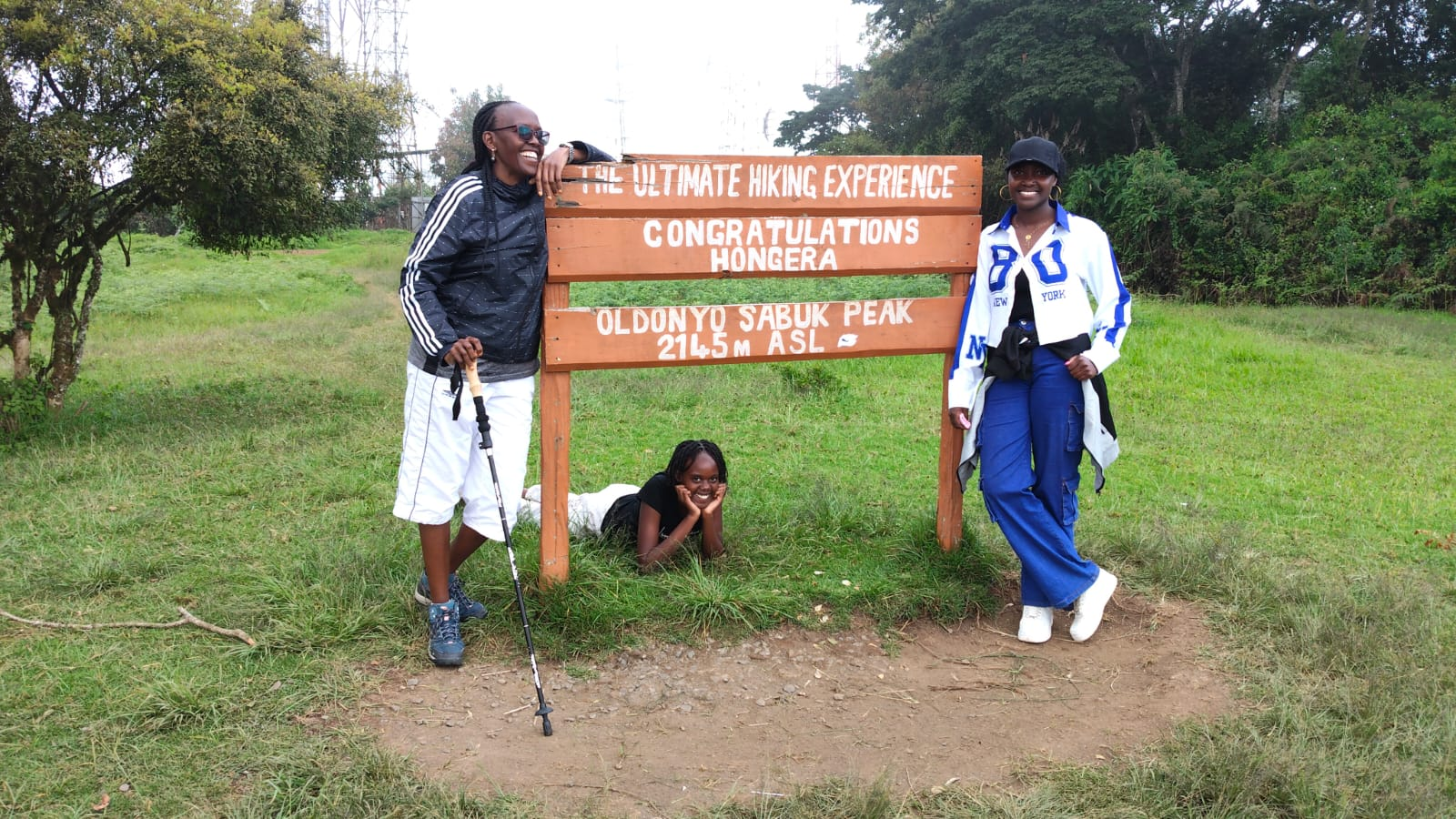 Rev. Irene with family at the Oldonyo Sabuk Peak sign